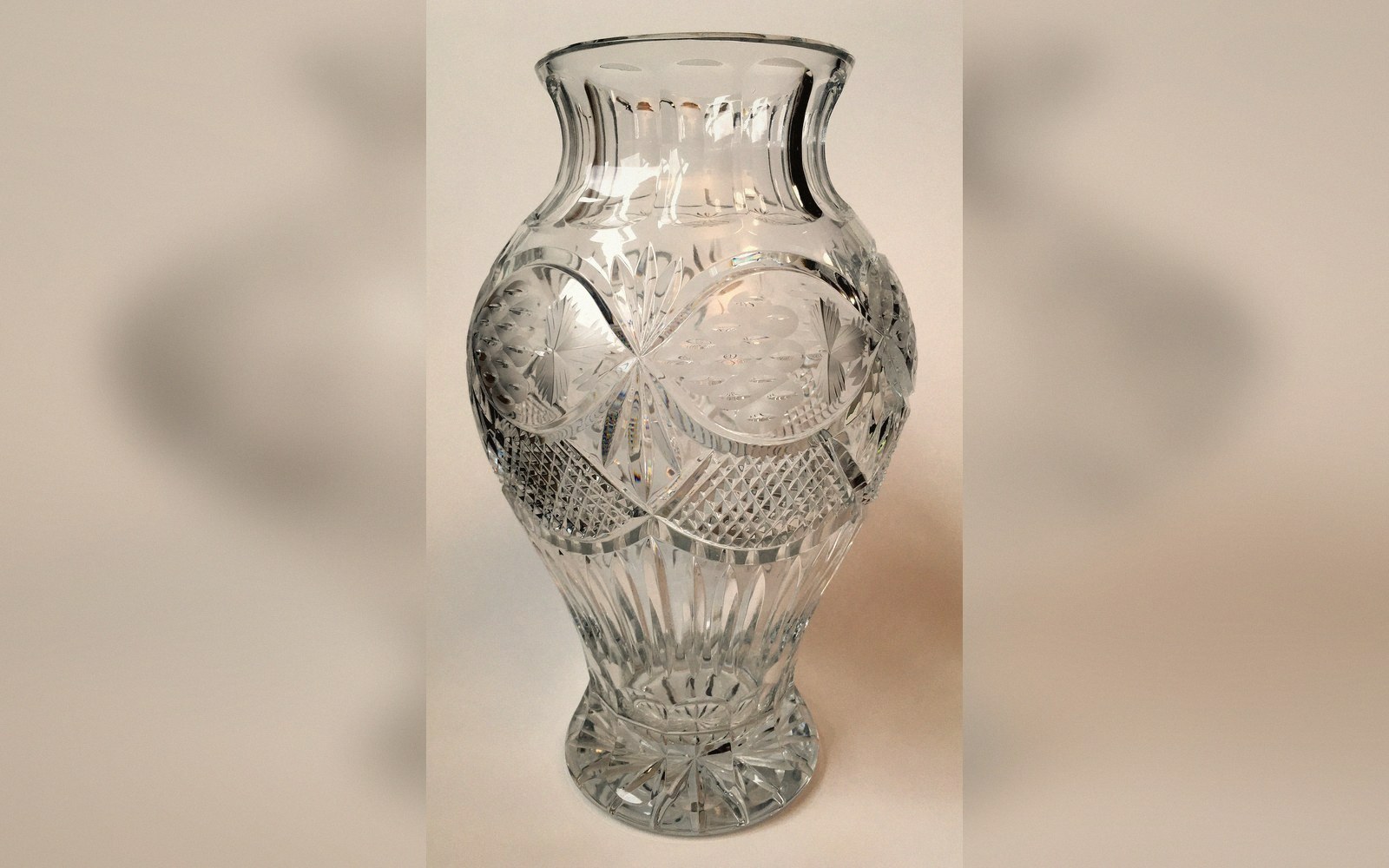 Cut crystal vase with a faceted star and diamond pattern on a bulbous body
